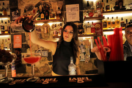 Dana, 24, a bartender, pours a drink inside a bar in the Old City of Damascus, Syria, September 13, 2018. "During the war, when bombs were falling, it could be days without customers, but we never stopped working," Dana said. For much of the war the eastern Ghouta rebels fired mortars into Damascus, including the Old City, where shrapnel marks are often visible scored into streets or walls. Cafes spill out onto the cobbled streets of the Old City at night as carefully coiffed barbers give fashionable haircuts to young men, and groups of friends gather to play guitars. REUTERS/Marko Djurica