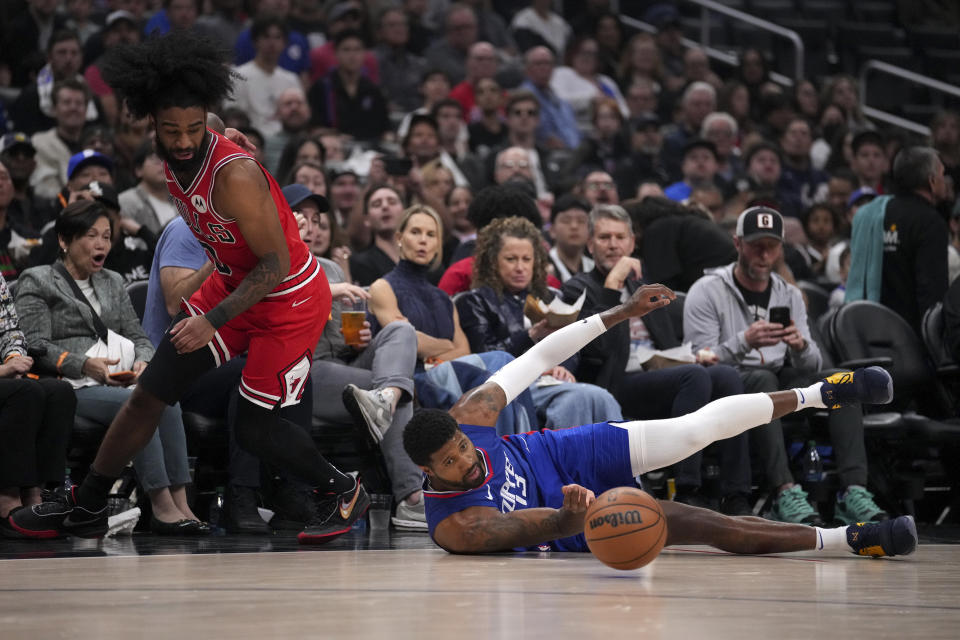 Chicago Bulls guard Coby White, left, and Los Angeles Clippers forward Paul George, right, fight for the ball during the first half of an NBA basketball game in Los Angeles, Saturday, March 9, 2024. (AP Photo/Eric Thayer)