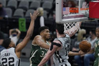 Milwaukee Bucks forward Giannis Antetokounmpo (34) scores past San Antonio defenders Rudy Gay (22) and Drew Eubanks (14) during the first half of an NBA basketball game in San Antonio, Monday, May 10, 2021. (AP Photo/Eric Gay)