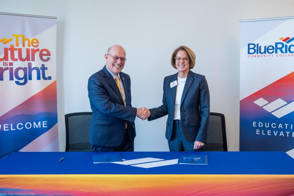 Mars Hill University President John Anthony Floyd, left, and Blue Ridge Community College President Dr. Laura B. Leatherwood shake hands following the signing of a new agreement between the institutions on Jan. 29 at BRCC.