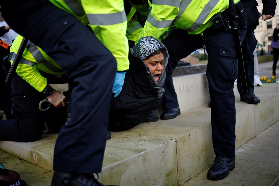 TOPSHOT - Police officers detain a protestor during an anti-COVID-19 lockdown demonstration outside the Houses of Parliament in Westminster, central London on January 6, 2021. - Britain toughened its coronavirus restrictions on Tuesday, with England and Scotland going into lockdown and shutting schools, as surging cases have added to fears of a new virus variant. (Photo by Tolga Akmen / AFP) (Photo by TOLGA AKMEN/AFP via Getty Images)