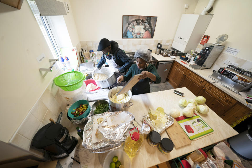 Chief coordinator Glenda Andrew and volunteer Dave Williams work in the kitchen to prepare West Indian meals, at the Xaverian Sanctuary, in Preston, England, Friday Feb. 19, 2021. Once a week they distribute meals to people in Preston and surrounding communities in northwestern England that have recorded some of the U.K.’s highest coronavirus infection rates. The meal program grew out of Andrew’s work with Preston Windrush Generation & Descendants, a group organized to fight for the rights of early immigrants from the Caribbean and other former British colonies who found themselves threatened with deportation in recent years. (AP Photo/Jon Super)