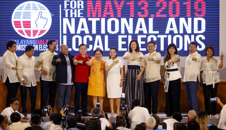 Twelve newly-proclaimed senators gesture their own political party symbols during a ceremony at the Commission on Elections in suburban Pasay city, south of Manila, Philippines Wednesday, May 22, 2019. They are, from left, Senators Bong Revilla, Francis Tolentino, Lito Lapid, Ronald Dela Rosa, Christopher Go, Cynthia Villar, Grace Poe, Pia Cayetano, Sonny Angara, Imee Marcos, Aquilino Pimentel and Nancy Binay. (AP Photo/Bullit Marquez)