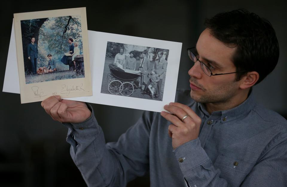 Auctioneer Paul Fairweather holds Christmas cards from 1957 and 1965 showing Queen Elizabeth II and the Duke of Edinburgh alongside their children, at Omega Auctions in Stockport.   (Photo by Dave Thompson/PA Images via Getty Images)