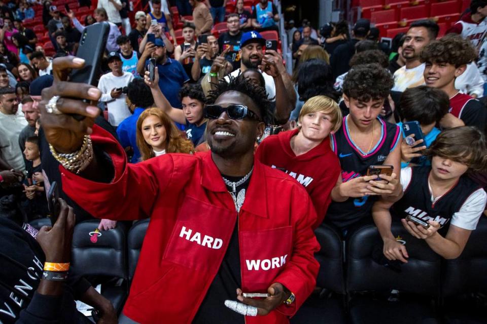 Former NFL player Antonio Brown takes a selfie with fans after the fourth quarter of an NBA game between the Miami Heat and the Brooklyn Nets at FTX Arena in Downtown Miami, Florida, on Saturday, March 26, 2022.