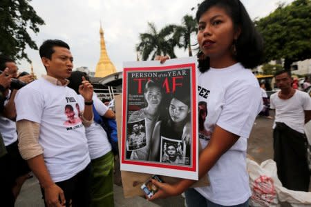 Activists hold the newly released Time Magazine cover at a rally, calling for the release of imprisoned Reuters journalists Wa Lone and Kyaw Soe Oo, one year after they were arrested, in Yangon, Myanmar December 12, 2018. REUTERS/Myat Thu Kyaw