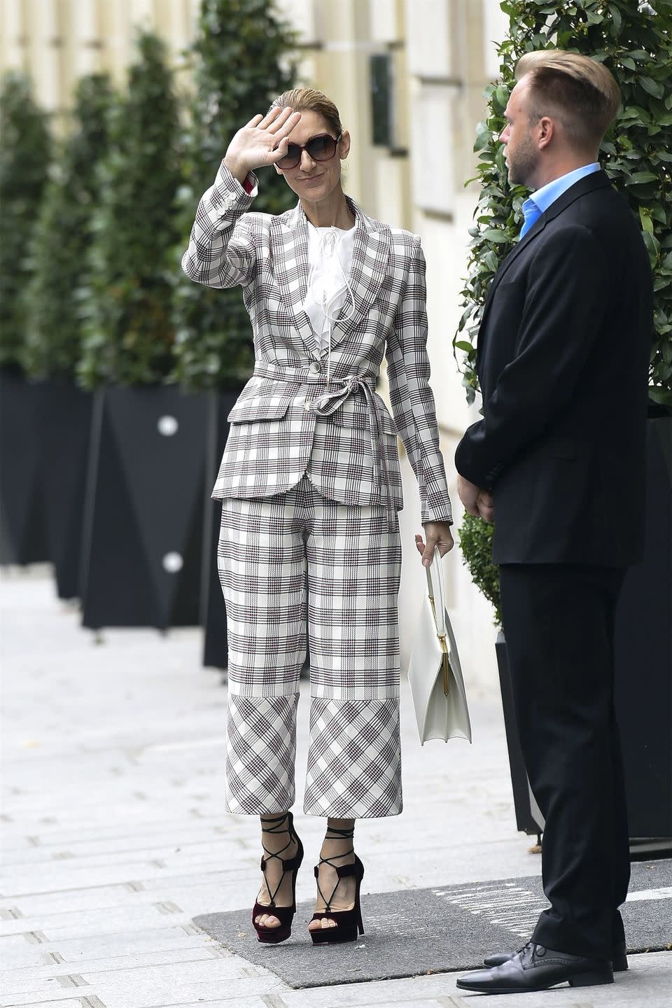 <p>In an Antonio Berardi plaid pantsuit, red velvet platform heels, oversized sunglasses and a white bag out in Paris. </p>