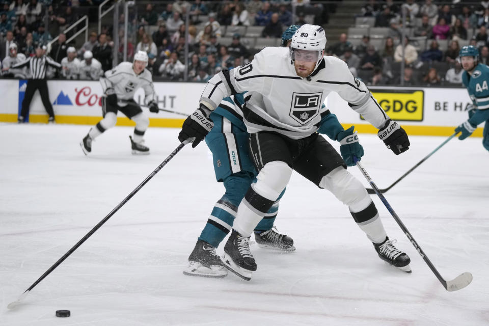Los Angeles Kings center Pierre-Luc Dubois (80) reaches for the puck in front of San Jose Sharks center Jack Studnicka during the second period of an NHL hockey game in San Jose, Calif., Tuesday, Dec. 19, 2023. (AP Photo/Jeff Chiu)