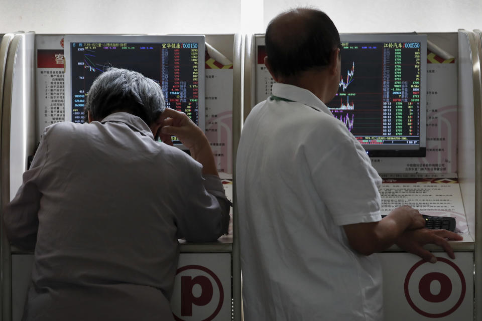Chinese investors check stock prices at a brokerage house in Beijing, Thursday, Sept. 19, 2019. Shares were mixed in Asia on Thursday, with Tokyo and Sydney logging modest gains after the Federal Reserve cut its benchmark interest rate for a second time this year, citing slowing global economic growth and uncertainty over U.S. trade conflicts. (AP Photo/Andy Wong)