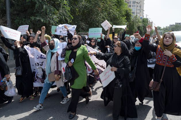 Afghan women hold placards as they march and shout slogans 