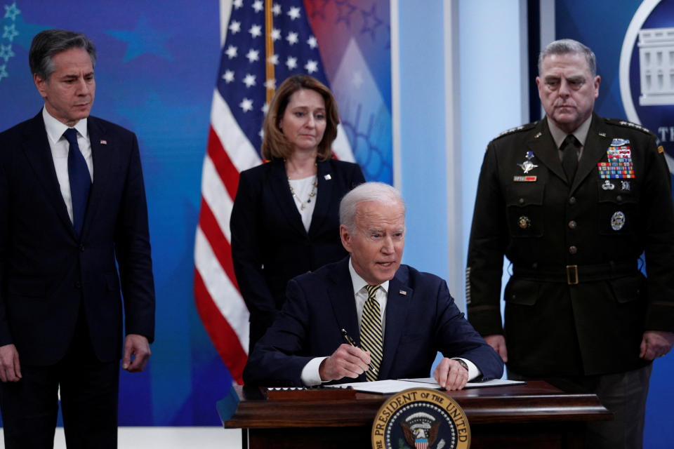 Le président américain Joe Biden est flanqué du secrétaire d'État Antony Blinken, de la sous-secrétaire à la Défense Kathleen Hicks et du président de l'état-major interarmées, le général Mark Milley, alors qu'il parle de l'aide que le gouvernement américain fournit à l'Ukraine dans le cadre de l'invasion de la Russie. le pays voisin, avant de signer un décret sur l'aide à l'auditorium de la cour sud de l'immeuble de bureaux Eisenhower à la Maison Blanche à Washington, États-Unis, le 16 mars 2022. REUTERS/Tom Brenner