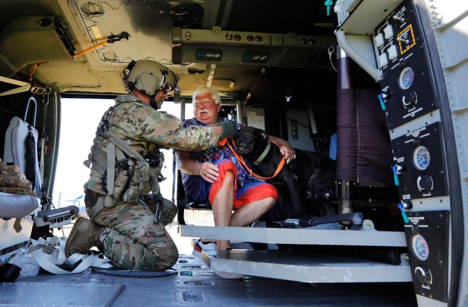 Pine Island resident Tom O'Sullivan is evacuated along with his dog Jack by a member of a Florida Army National Guard helicopter crew out of Jacksonville. The crew assisted in the evacuation efforts stationed at Matlacha / Pine Island Fire station One, Sunday October 02, 2022.