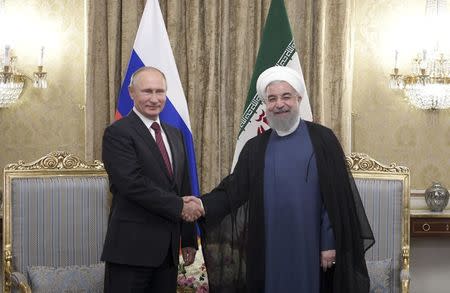 Russian President Vladimir Putin (L) shakes hands with his Iranian counterpart Hassan Rouhani during a meeting in Tehran, Iran November 1, 2017. Sputnik/Alexei Druzhinin/Kremlin via REUTERS