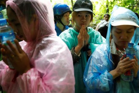 Family members pray near Tham Luang caves during a search for 12 members of an under-16 soccer team and their coach, in the northern province of Chiang Rai, Thailand, June 27, 2018. REUTERS/Soe Zeya Tun