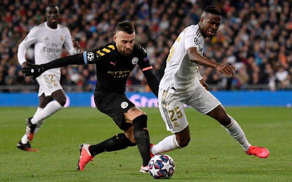 Manchester City's Argentinian defender Nicolas Otamendi (L) vies with Real Madrid's Brazilian forward Vinicius Junior during the UEFA Champions League round of 16 first-leg football match between Real Madrid CF and Manchester City -  PIERRE-PHILIPPE MARCOU/AFP via Getty Images