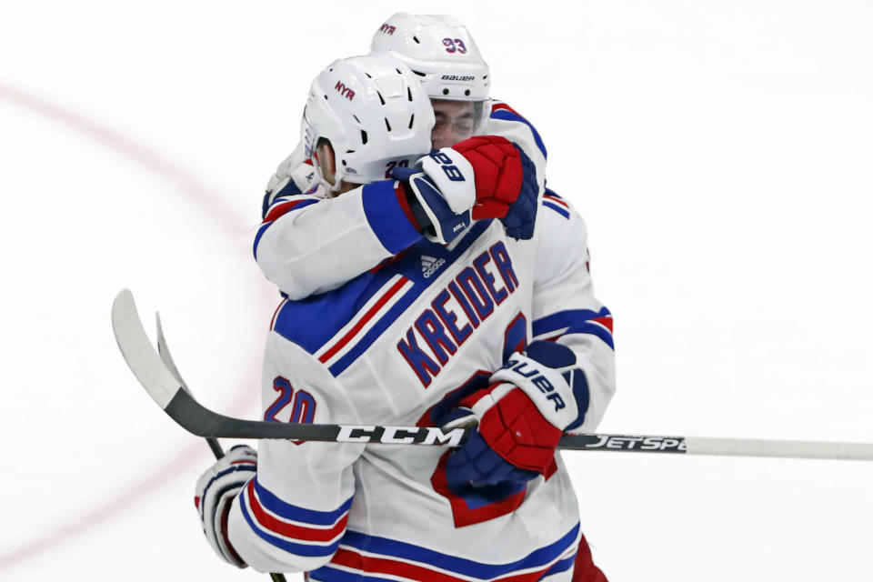 New York Rangers center Mika Zibanejad (93) embraces New York Rangers left wing Chris Kreider (20) after scoring the winning goal in overtime of an NHL hockey game against the New York Islanders, Tuesday, Feb. 25, 2020, in Uniondale, N.Y. The Rangers won 4-3. (AP Photo/Kathy Willens)