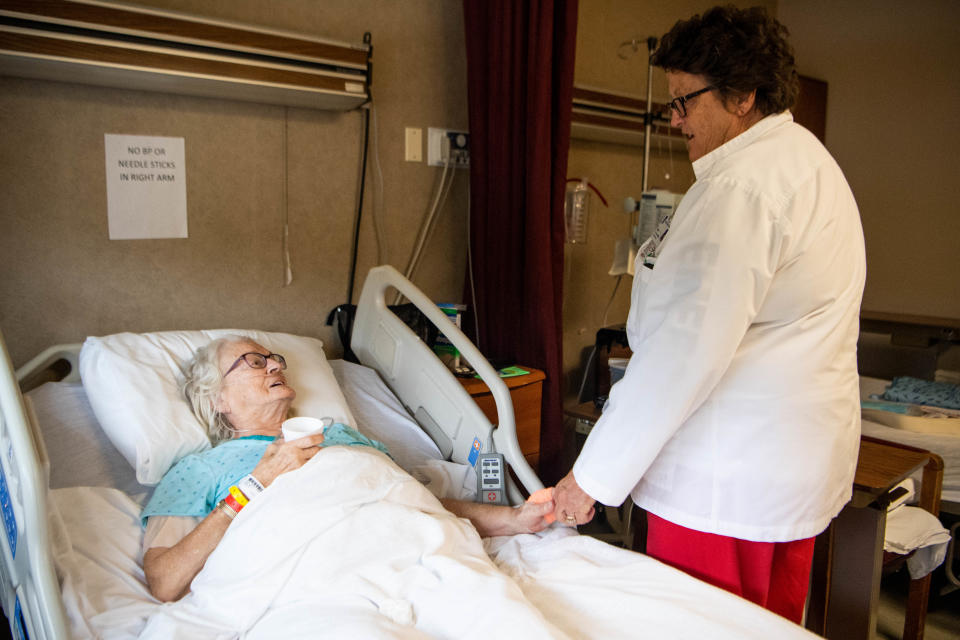 Betty Harvey, 83, left, holds hands with nurse Nancy Daniel while recovering from pneumonia at Three Rivers Hospital on Oct. 29, 2019. The hospital is at risk of closure, but Harvey calls it "home."