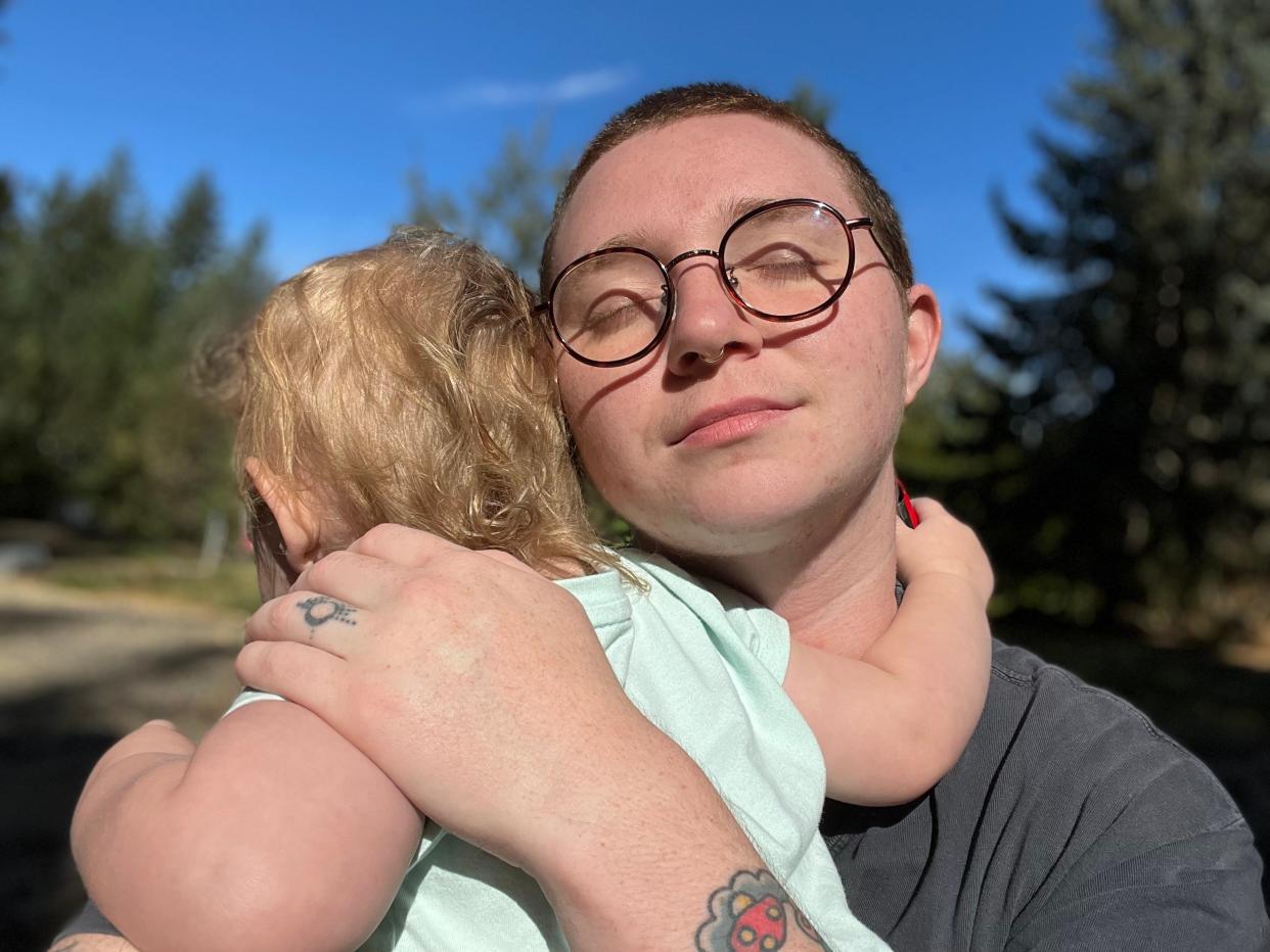 Writer Sage Agee hugging their child in the sun