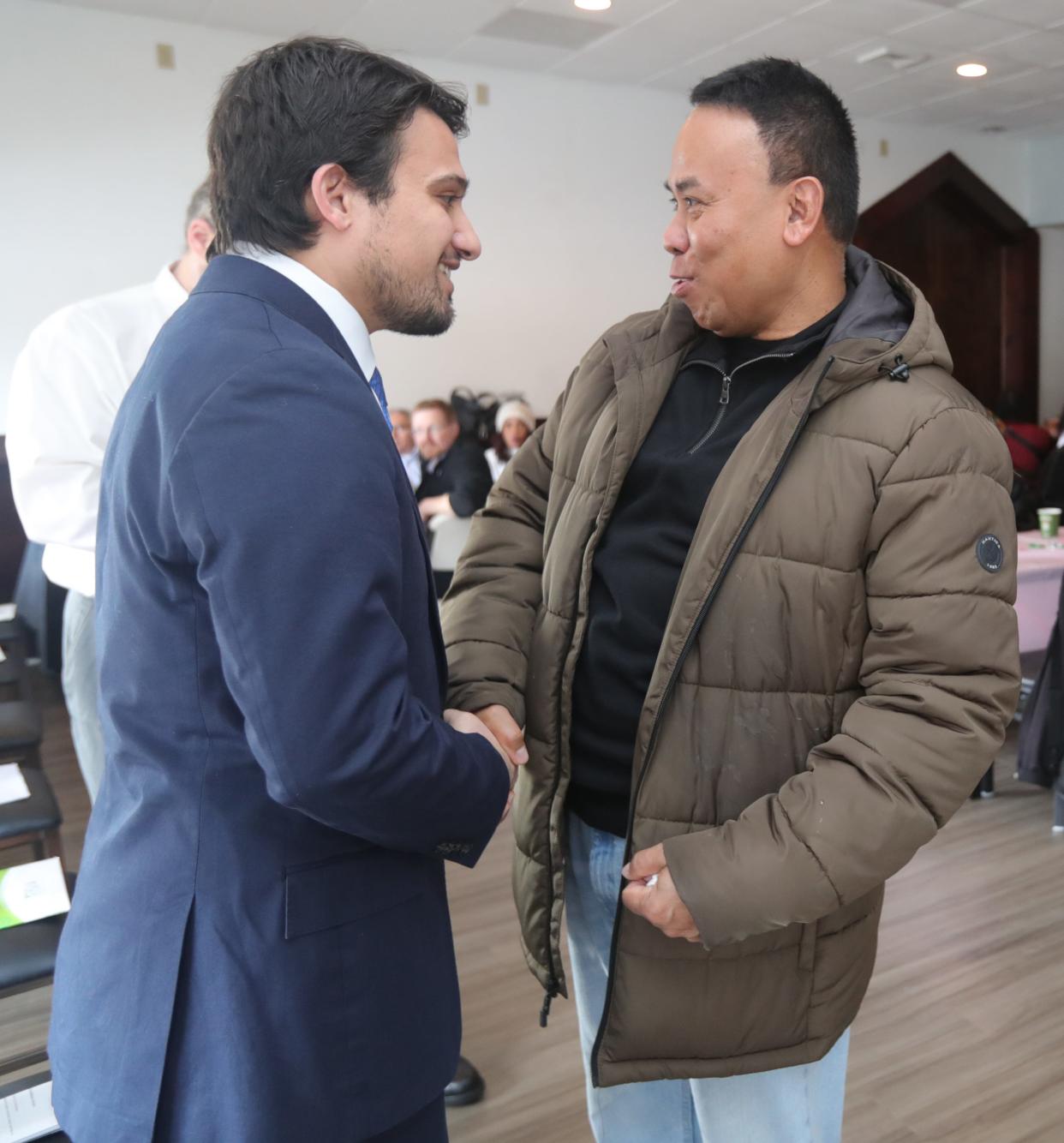 Councilman Shammas Malik, left, talks with Akron resident Banya Mehm before a mayoral candidate forum Saturday at Mon Thai-Malay Restaurant in Akron.