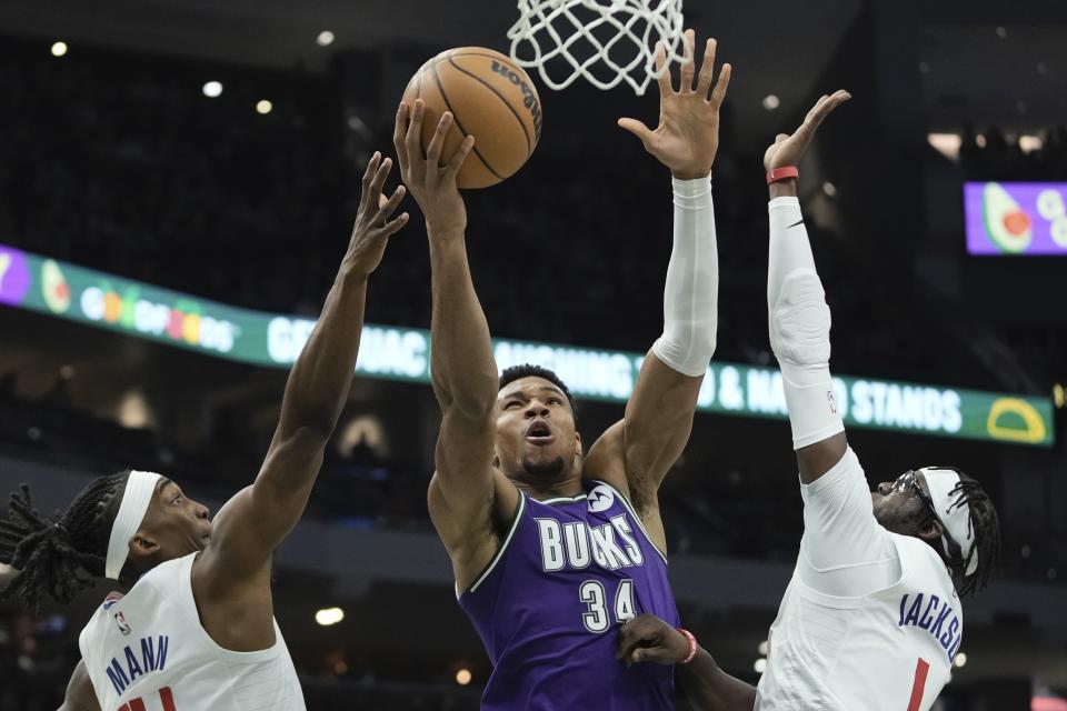 Milwaukee Bucks' Giannis Antetokounmpo shoots between Los Angeles Clippers' Terance Mann and Reggie Jackson during the first half of an NBA basketball game Thursday, Feb. 2, 2023, in Milwaukee. (AP Photo/Morry Gash)