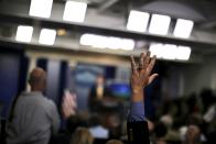 A reporter raises his hand as White House Press Secretary Josh Earnest speaks during a press briefing at the White House in Washington July 30, 2015. The White House said on Thursday that it will review the public petition to extradite the American dentist who allegedly killed "Cecil," a Zimbabwean lion. (REUTERS/Carlos Barria)