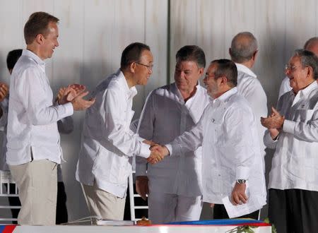 United Nations Secretary-General Ban Ki-moon (2nd L) and Marxist rebel leader Rodrigo Londono (2nd R), better known by the nom de guerre Timochenko, shake hands as Colombia's President Juan Manuel Santos (C) looks on, in Cartagena, Colombia September 26, 2016. REUTERS/John Vizcaino