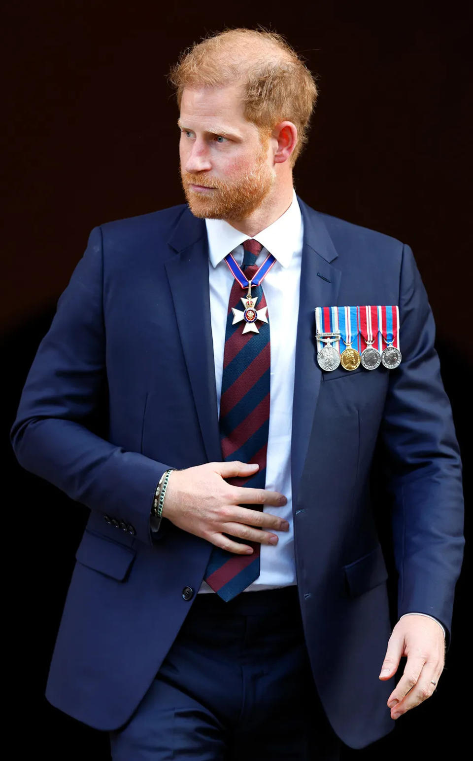 Prince Harry wearing a navy suit with medals