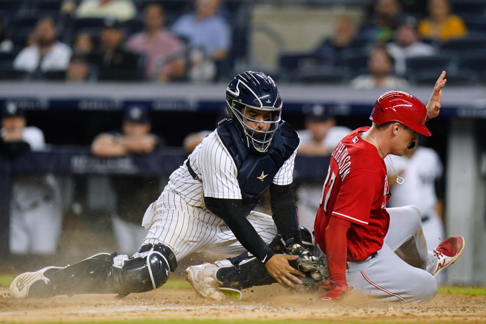 Cincinnati Reds' Tyler Stephenson (37) slides past New York Yankees catcher Jose Trevino to score on a Donovan Solano single during the 10th inning of a baseball game Thursday, July 14, 2022, in New York. The Reds won 7-6. (AP Photo/Frank Franklin II)