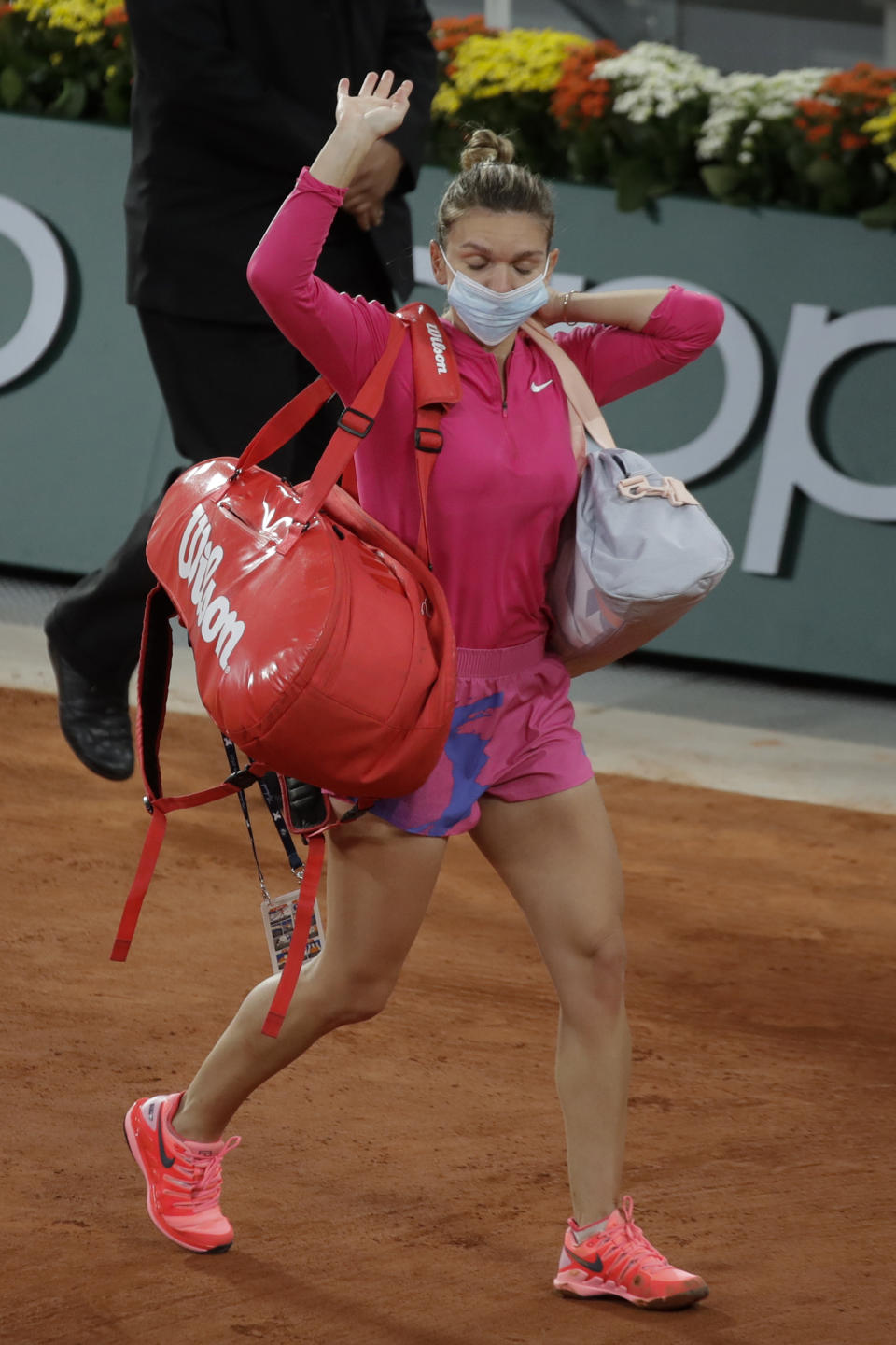 FILE - In this file photo dated Sunday, Oct. 4, 2020, Romania's Simona Halep wears a face mask as she leaves after losing her fourth round match of the French Open tennis tournament against Poland's Iga Swiatek at the Roland Garros stadium in Paris, France. Simona Halep said Saturday Oct. 31, 2020, that she has tested positive for COVID-19 coronavirus. (AP Photo/Alessandra Tarantino, FILE)