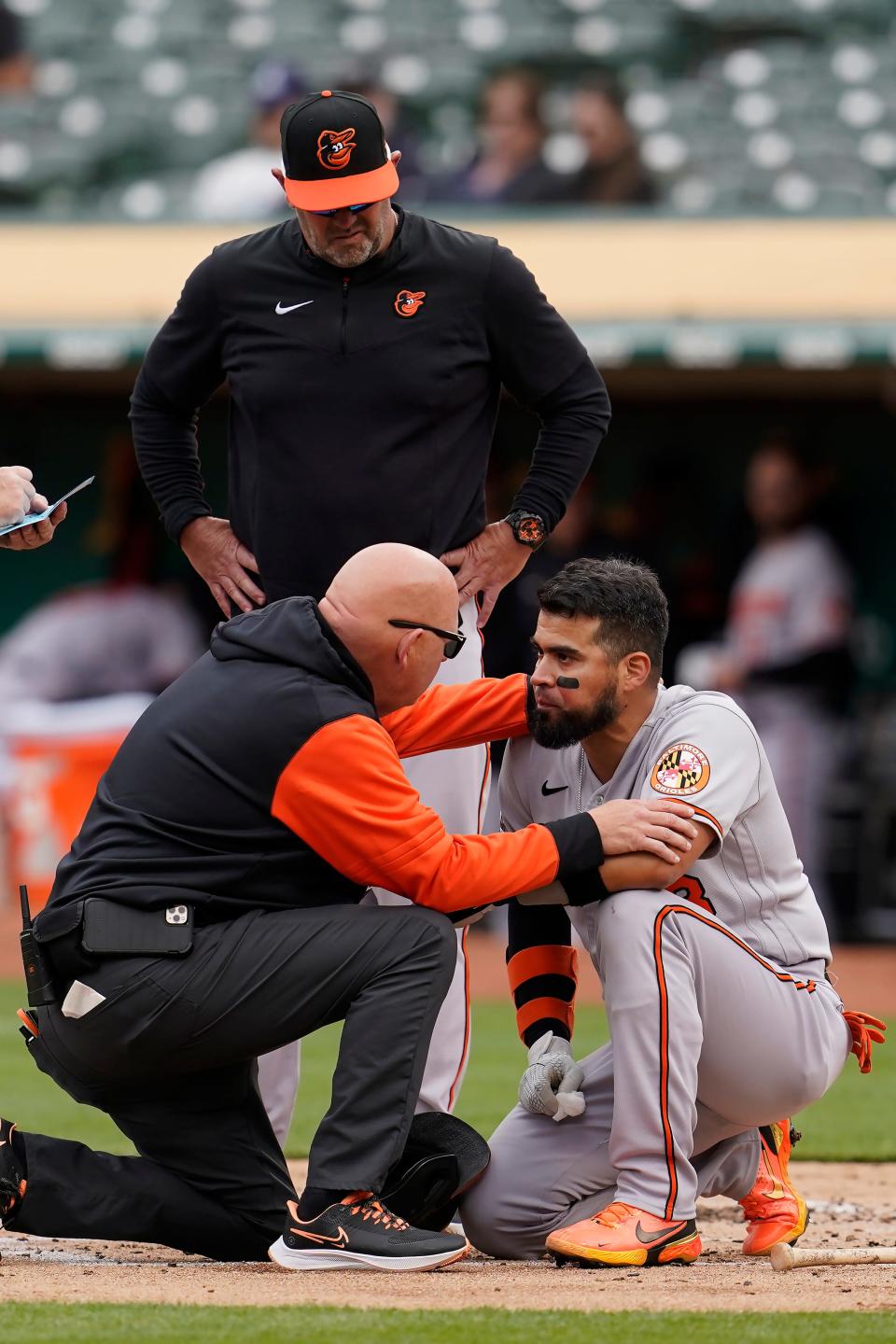 While every profession and college team typically has numerous athletic trainers on staff, one in three American high schools do not have access to a certified athletic trainer. In this photo, Baltimore Orioles' Robinson Chirinos, bottom right, is checked on by a trainer and manager Brandon Hyde, top, after being hit by a pitch by Oakland Athletics pitcher Daulton Jefferies during the second inning of a baseball game in Oakland, Calif., Wednesday, April 20, 2022.