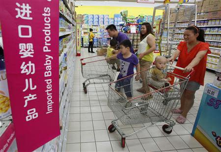 A family looks at foreign imported milk powder products at a supermarket in Beijing in this July 3, 2013 file photo. REUTERS/Kim Kyung-Hoon/Files