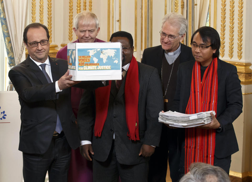 FILE - France's President Francois Hollande, left, holds a box containing an international petition to support the climate talks as he poses with bishop of Salisbury Nicholas Holtam, from second left, Cameroon's Augustine Njamnshi of the Pan African Climate Justice Alliance, Bishop of Brazil Leonardo Steiner and a unidentified representative of a pilgrim group at the Elysee Palace in Paris, Thursday, Dec. 10, 2015. When Steiner kneels before Pope Francis on Aug. 27, the Brazilian clergyman will make history as the first cardinal to come from the Amazon. (AP Photo/Michel Euler, Pool, File)
