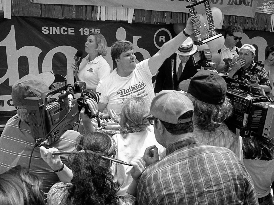 American competitive eater Edward Krachie holds a trophy in his hands as he celebrates his victory in the 1995 Nathan's Hot Dog Eating Contest at Coney Island