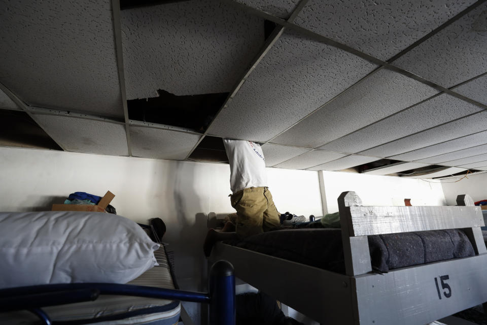 In this July 31, 2019, photo, a man from Africa uses the ceiling space above his bunk to store his valuables at El Buen Pastor shelter for migrants in Cuidad Juarez, Mexico. (AP Photo/Gregory Bull)