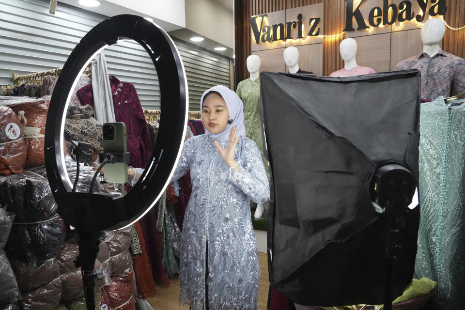 A trader conducts live sales via streaming at a store in the Tanah Abang textile market in Jakarta, Indonesia Thursday, Sept. 28, 2023. Chinese-owned app TikTok on Thursday said it regretted the Indonesian government's decision to ban e-commerce transactions on social media platforms, particularly the impact it would have on the millions of sellers who use TikTok Shop. (AP Photo/Tatan Syuflana)