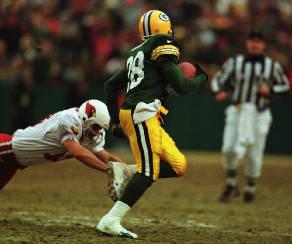 Basil Mitchell runs past Cardinals kicker Chris Jacke on his way to a touchdown.