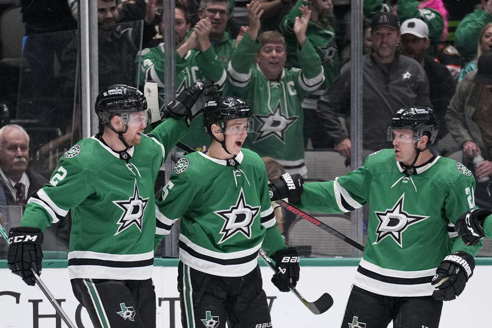 Dallas Stars' Jani Hakanpää (2), Nils Lundkvist (5) and Ryan Suter (20) celebrate after Lundkvist scored in the first period of an NHL hockey game against the Anaheim Ducks, Monday, Feb. 6, 2023, in Dallas. (AP Photo/Tony Gutierrez)