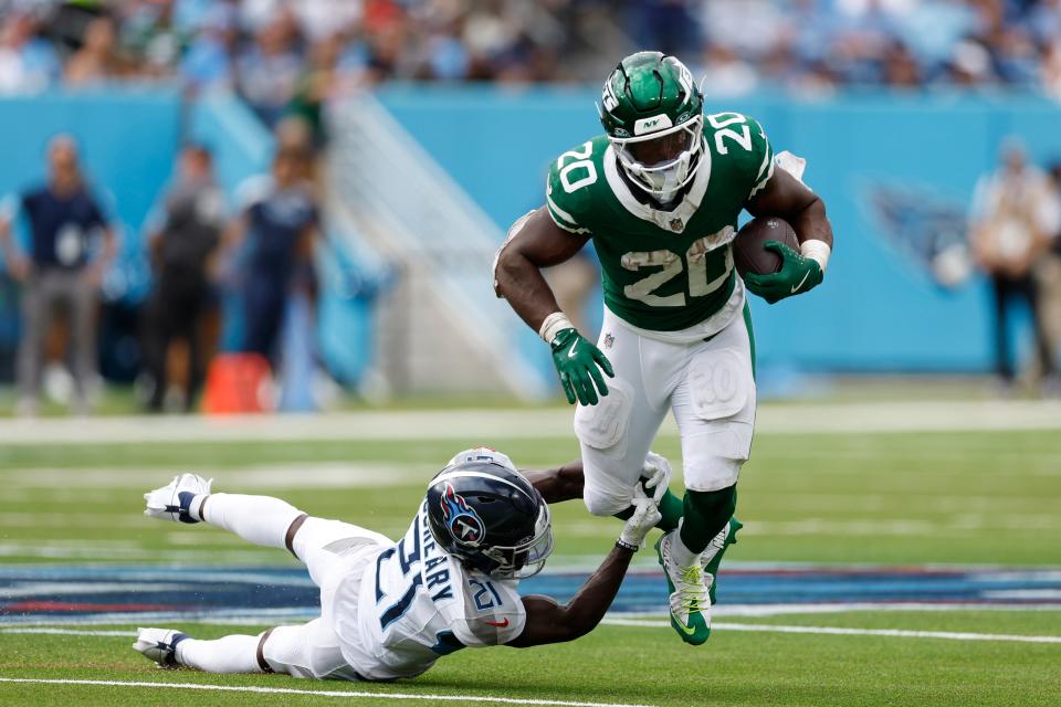 NASHVILLE, TENNESSEE - SEPTEMBER 15: Breece Hall #20 of the New York Jets is tackled by Roger McCreary #21 of the Tennessee Titans for a loss during the fourth quarter at Nissan Stadium on September 15, 2024 in Nashville, Tennessee. (Photo by Wesley Hitt/Getty Images)