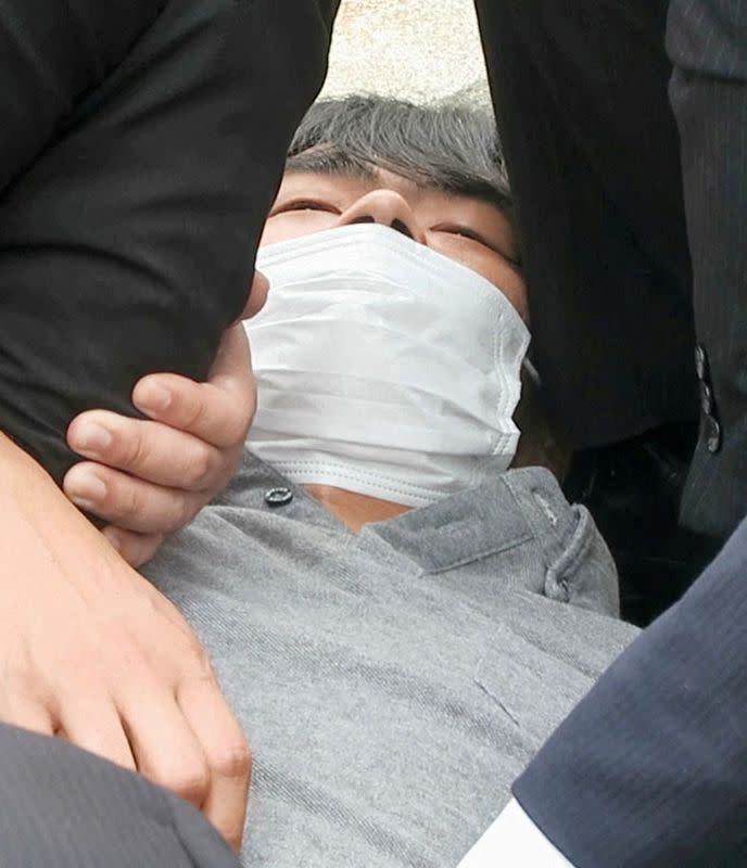 FILE PHOTO: This screen grab shows the suspect, identified as Tetsuya Yamagami, believed to have shot former Japanese Prime Minister Shinzo Abe, being held by police officers in Nara