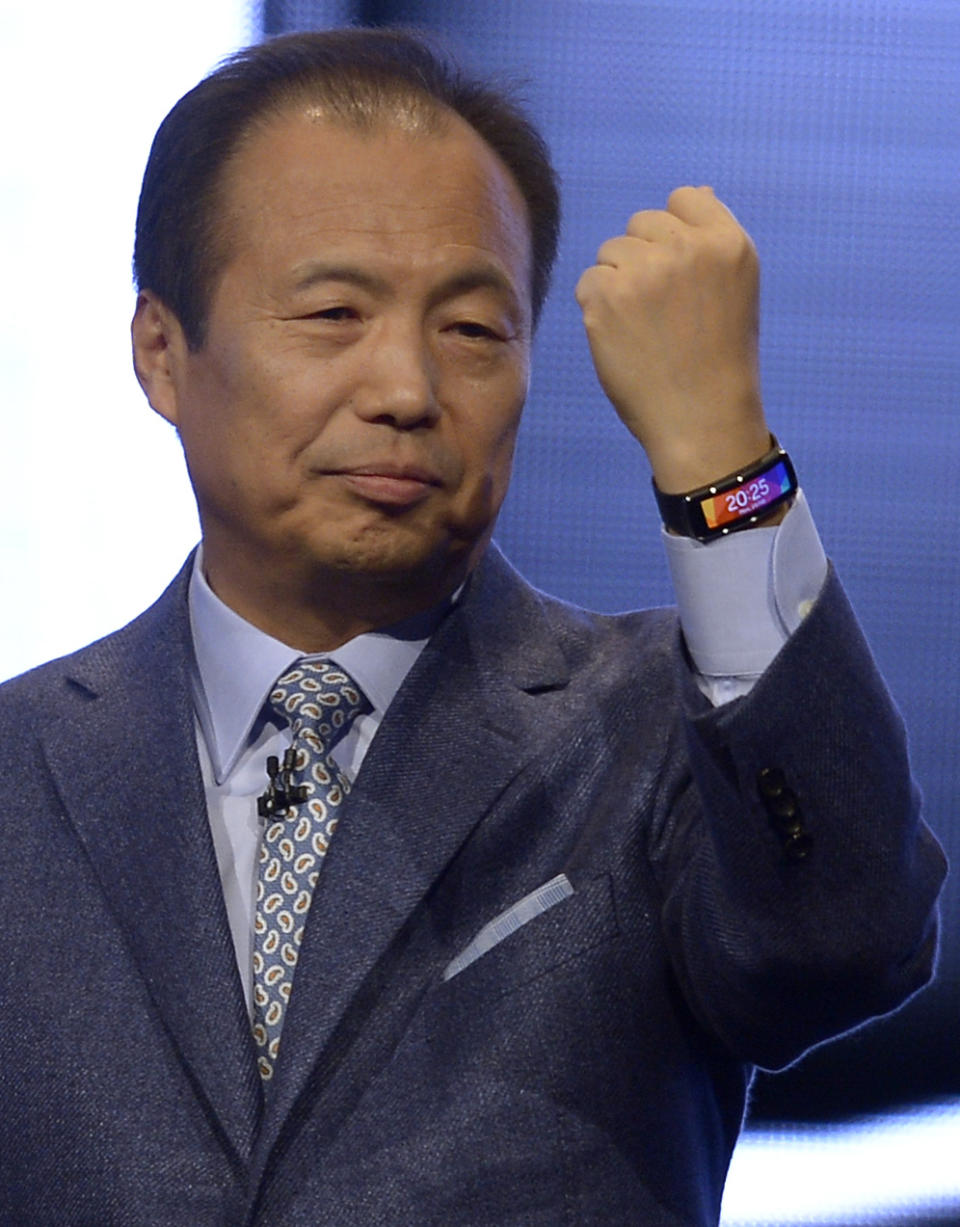 Samsung CEO J.K. Shin presents the new device Samsung Gear Fit at the Mobile World Congress, the world's largest mobile phone trade show in Barcelona, Spain, Monday, Feb. 24, 2014. Expected highlights include major product launches from Samsung and other phone makers, along with a keynote address by Facebook founder and chief executive Mark Zuckerberg. (AP Photo/Manu Fernandez)