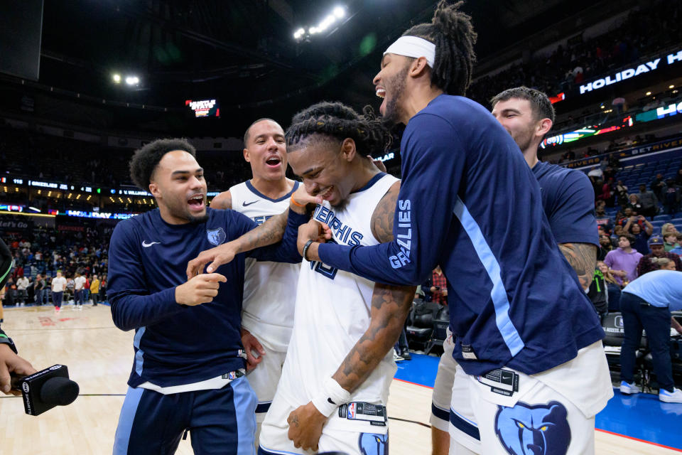 Memphis Grizzlies guard Ja Morant, center, is mobbed by teammates Jacob Gilyard, left, and Ziaire Williams, after scoring the winning basket to defeat the New Orleans Pelicans at the Smoothie King Center on Dec. 19, 2023 in New Orleans.