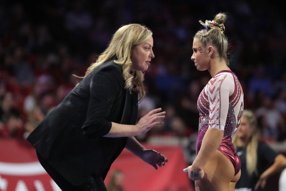 OU coach K.J. Kindler, left, talks with Ragan Smith during a women's college gymnastics meet against Florida on March 3 at Lloyd Noble in Norman.