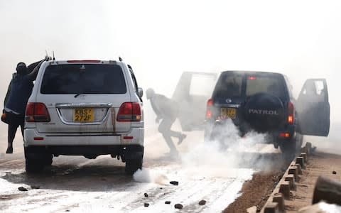 Kathiani Member of Parliament Robert Mbui (beneath the darker vehicle number plate) is hit by another car as riot police disperse the convoy of Kenyan opposition leader Raila Odinga  - Credit: REUTERS