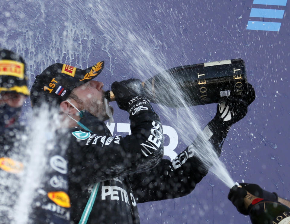 Race winner, Mercedes driver Valtteri Bottas of Finland, centre, drinks champagne by second placed Red Bull driver Max Verstappen of the Netherlands, left, after the Russian Formula One Grand Prix, at the Sochi Autodrom circuit, in Sochi, Russia, Sunday, Sept. 27, 2020. (Yuri Kochetkov, Pool Photo via AP)
