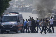 Palestinians carry an injured protester during clashes with the Israeli army while forces carry out an operation in the West Bank town of Nablus, Tuesday, Aug. 9, 2022. Israeli police said forces encircled the home of Ibrahim al-Nabulsi, who they say was wanted for a string of shootings in the West Bank earlier this year. They said al-Nabulsi and another Palestinian militant were killed in a shootout at the scene, and that troops found arms and explosives in his home. Palestinian health officials said three persons were killed and at least 40 people wounded in the gun battle on Tuesday. (AP Photo/Majdi Mohammed)