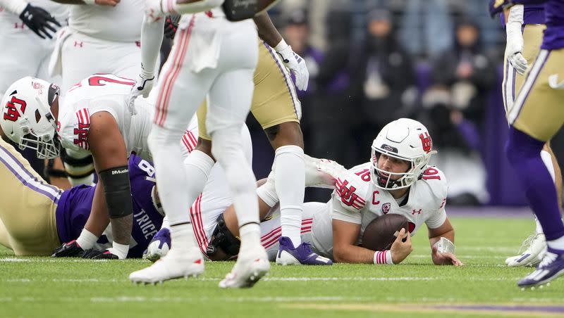 Utah quarterback Bryson Barnes (16) looks up after being tackled by Washington defensive end Bralen Trice (8) during an NCAA college football game on Nov. 11, 2023, in Seattle.
