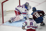 New York Rangers goaltender Igor Shesterkin (31) prepares to stop a redirected shot off the stick of Colorado Avalanche center Alex Newhook (18) after Newhook drove past Rangers defenseman Jacob Trouba (8) in the first period of an NHL hockey game Friday, Dec. 9, 2022, in Denver. (AP Photo/David Zalubowski)