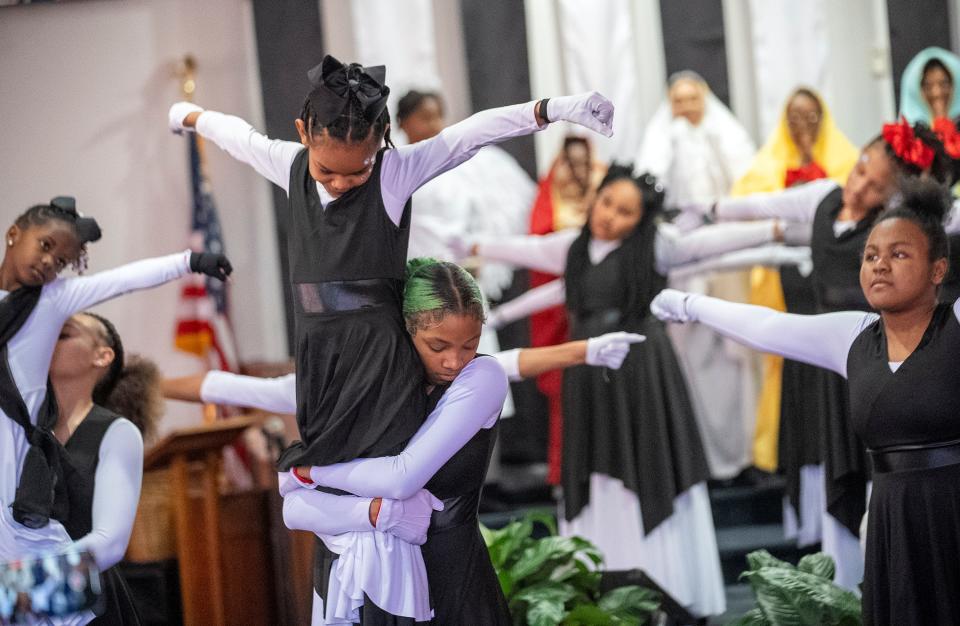 Mariah LaMarr holds up Payton Anderson, 9, as they perform with the Butterflies and Our Steps Are Ordered Dance Ministry during a special Easter performance presented Palm Sunday, March 24, at the Family Missionary Baptist Church in Columbus.