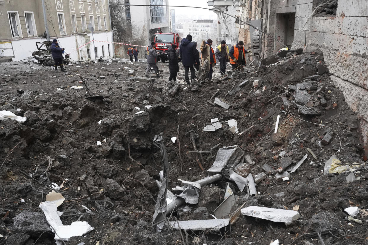 Emergency and municipal workers clear the rubble from a residential building which was hit by a Russian rocket, in the city center of Kharkiv, Ukraine, Sunday, Feb. 5, 2023. (AP Photo/Andrii Marienko)