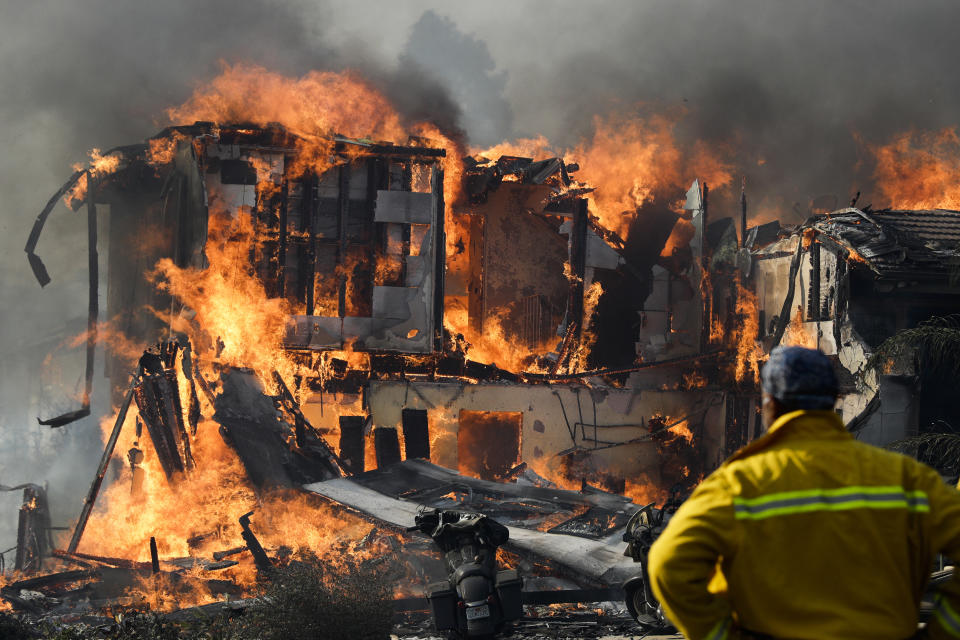 A wildfire consumes a home Tuesday, Dec. 5, 2017, in Ventura, Calif. Raked by ferocious Santa Ana winds, explosive wildfires northwest of Los Angeles and in the city’s foothills burned scores of homes Tuesday and forced the evacuation of tens of thousands of people. (AP Photo/Jae C. Hong)